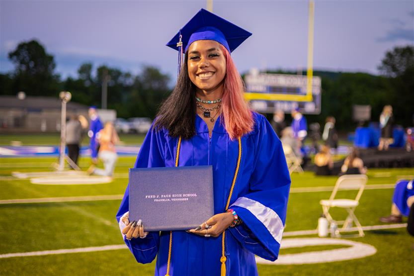 Students in blue robes graduate